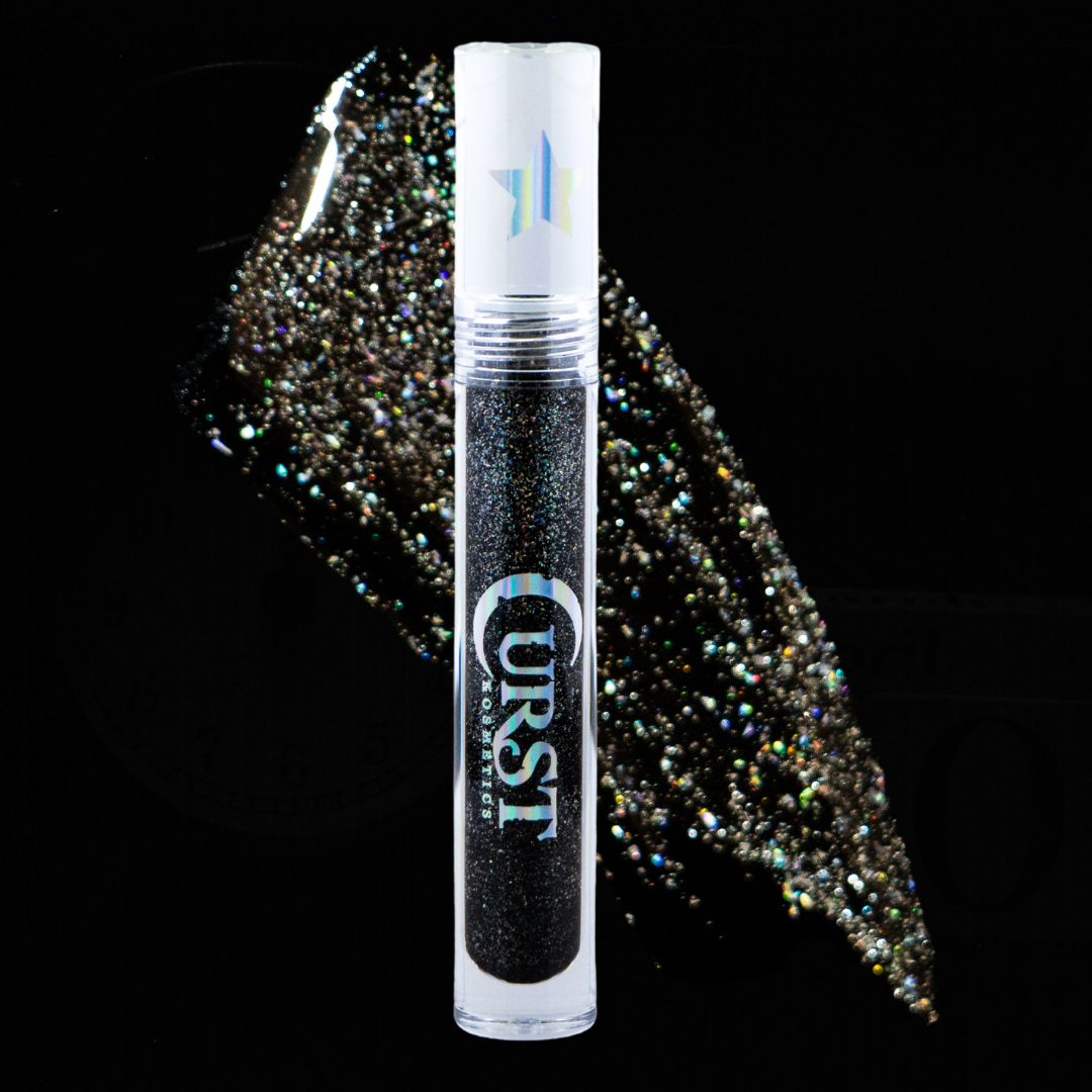 Lip gloss tube with glittery substance on a black background