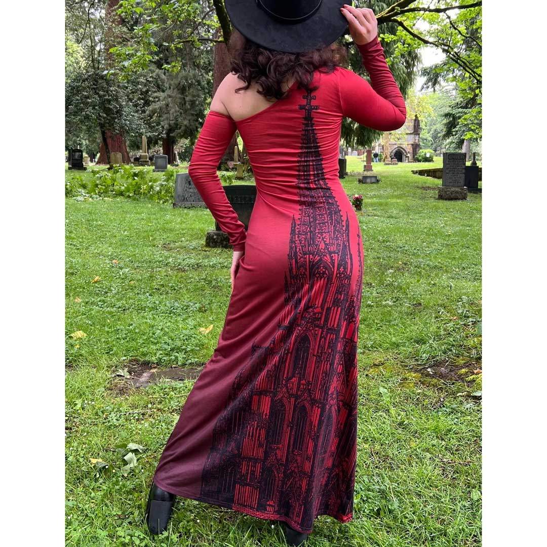 Person wearing a red dress with black patterns in an outdoor setting