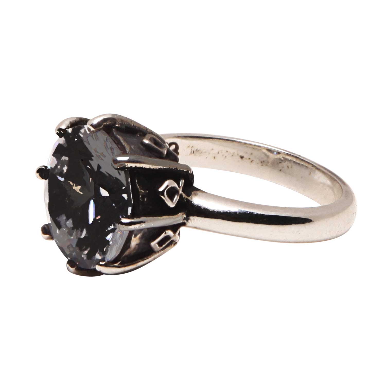 Silver ring with a large black gemstone on a white background