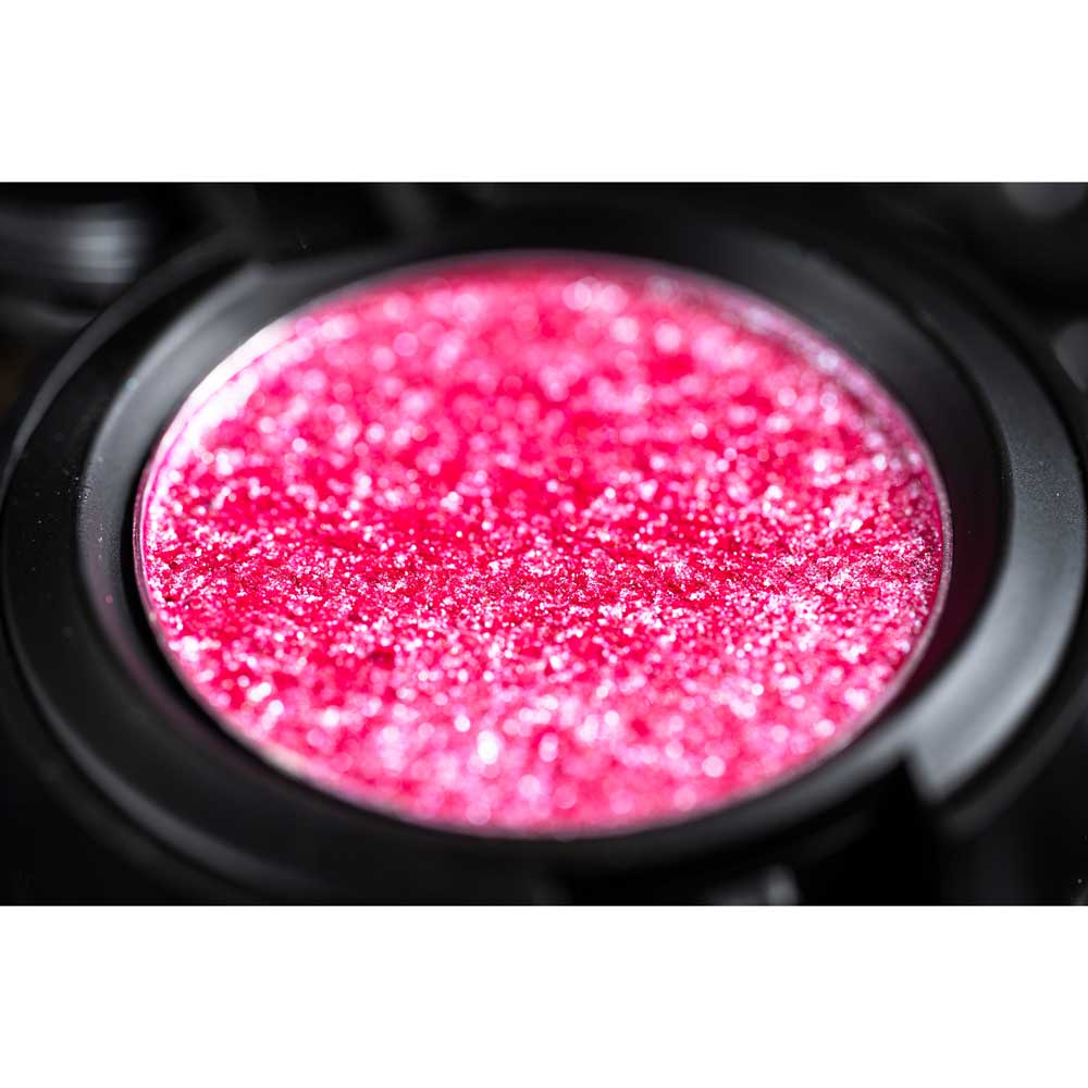 Close-up of a pink glittery substance in a black container.