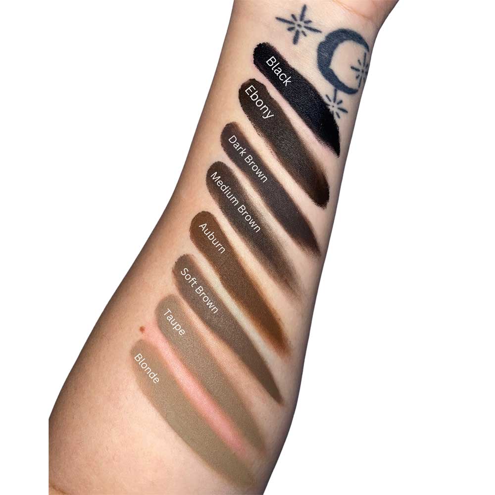 Swatches of different eyebrow shades on a person's arm with labels.