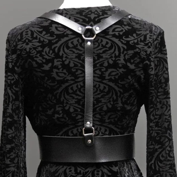 Black patterned dress with leather straps on a gray background