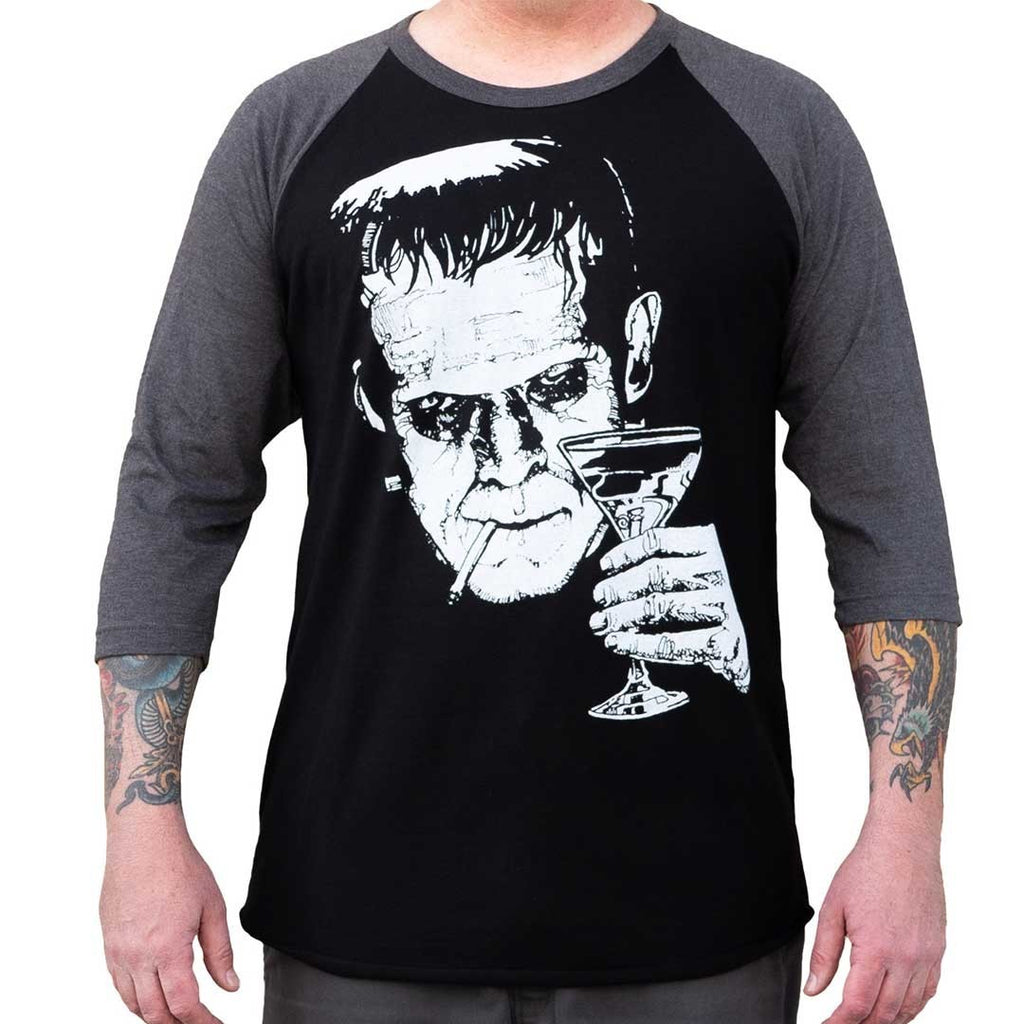 Black and gray baseball shirt with a graphic design of a face holding a martini glass.