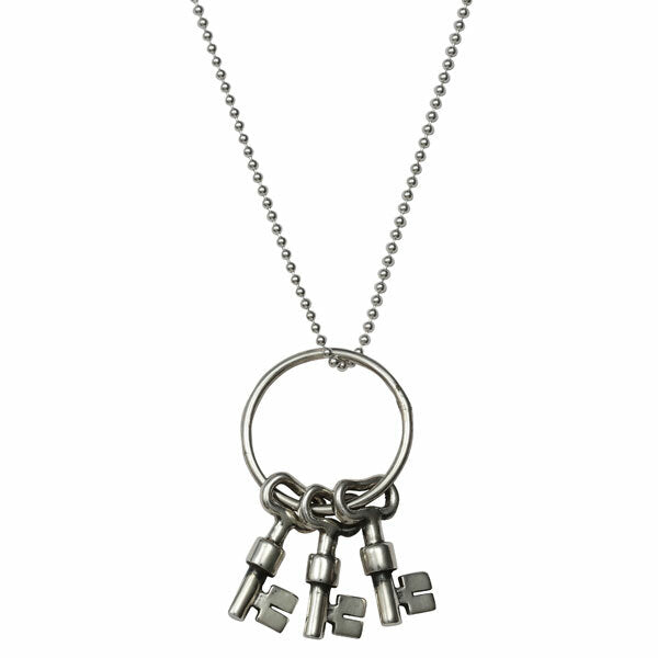 Silver necklace with a key pendant on a white background
