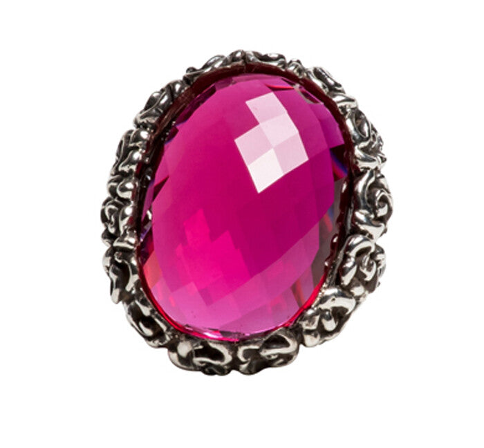 Ring with a pink gemstone and silver decorative band on a white background