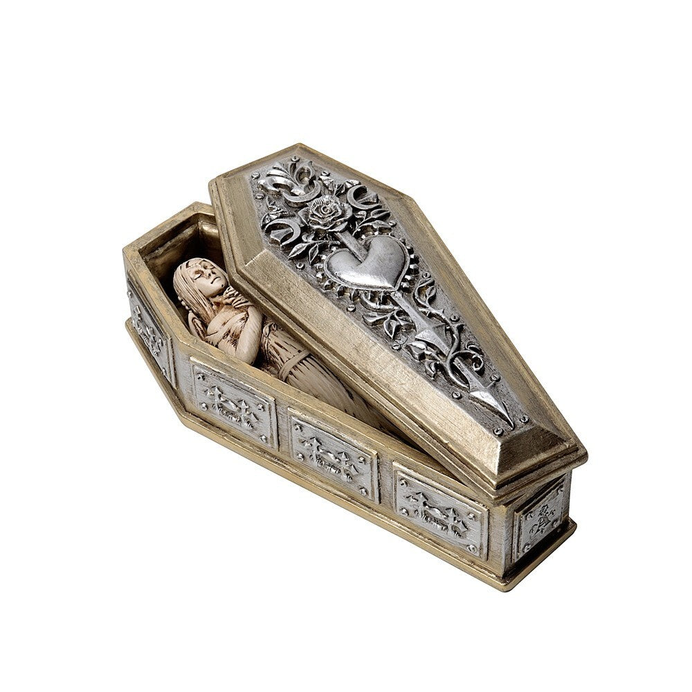 Decorative coffin box with intricate designs and a small figurine on a white background